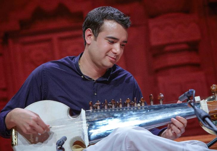 Colour photo of Alam Khan playing a sarod