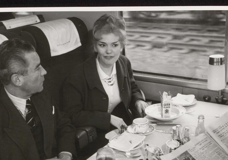 A man and a woman sit at a restaurant table in a Blue Pullman train