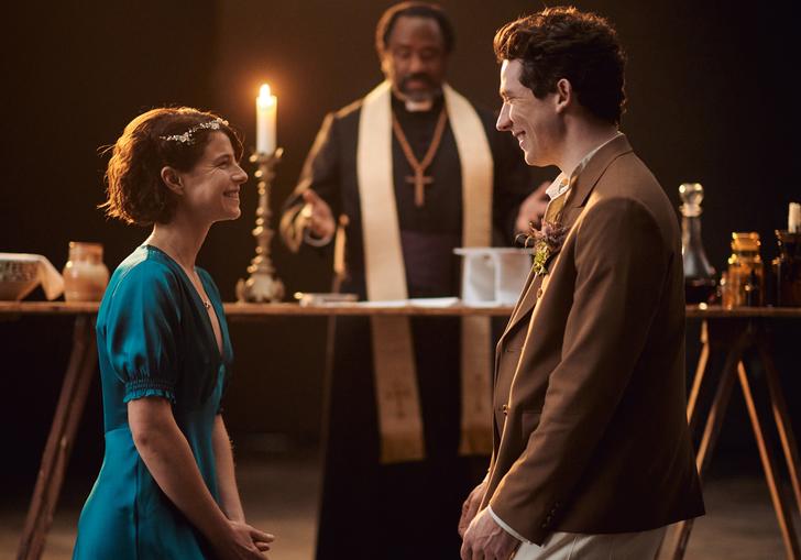 Romeo and Juliet sit opposite each other looking into each others eye with the priest behind them