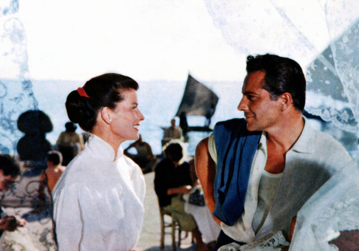 Katharine Hepburn in a white shirt looks at Rossano Brazzi, also in a white shirt, in front of a Venice canal in Summertime by David Lean