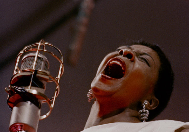 an artist sings into the mic at the Newport Jazz Festival