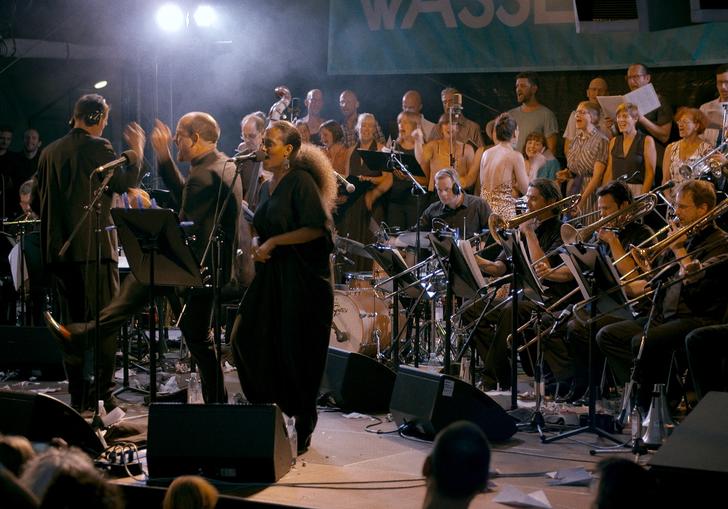 A live band are on stage in a still from A Symphony of Noise
