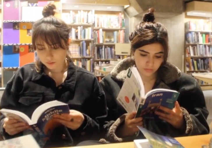 Two girls read travel guides for the Middle East and Iran in a still from Homeland