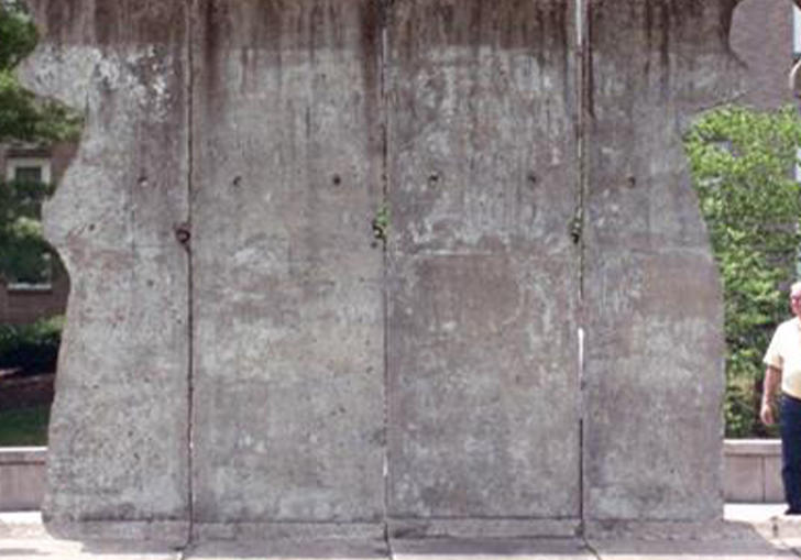 A still of a man standing by some Berlin Wall in documentary The American Sector