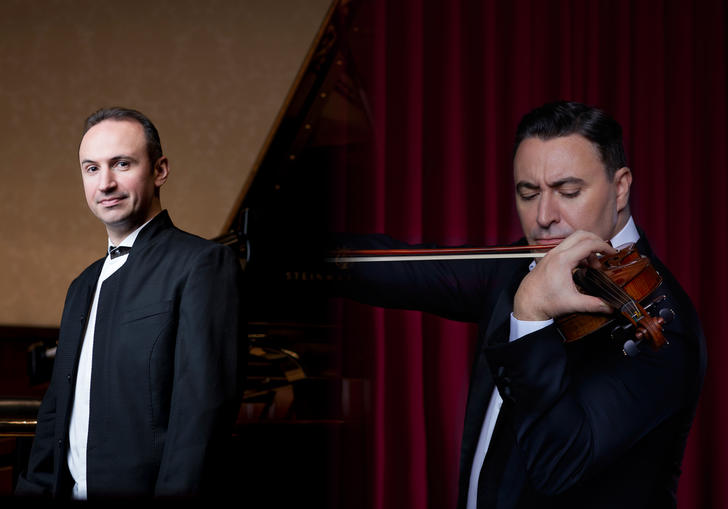 In the left of the image Simon Trpceski stands smiling in black tie in front of a piano. In the right of the image Maxim Vengerov is playing his violin.