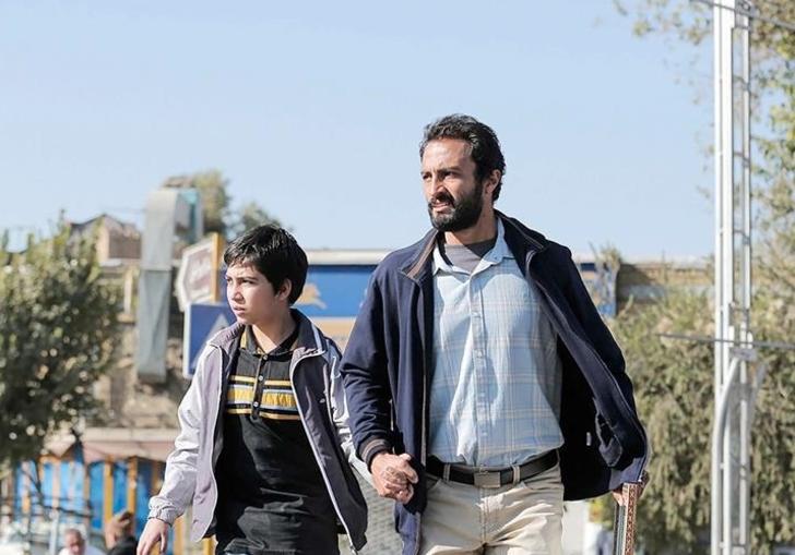 Still of Rahim and his son walking hurriedly 