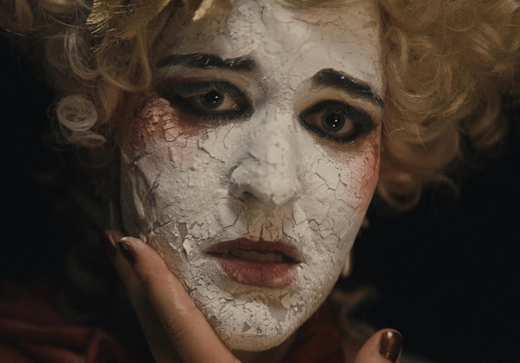 Actor in crumbling chalk white face paint