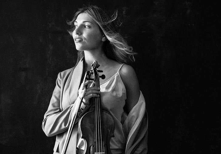 Black and white photo of Diana Tishchenko holding her violin