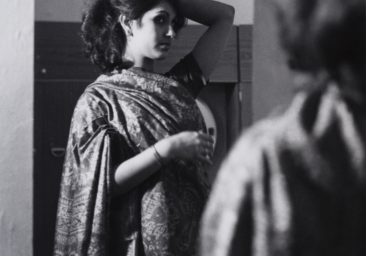 A young woman looks at her reflection, in a still from Mirror Mirror