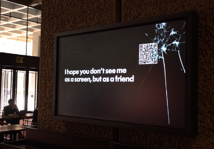 A screen on a concrete wall that says 'I hope you don't see me as a screen but as a friend'