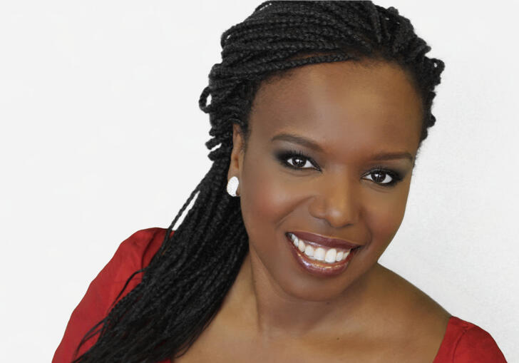 Nadine Benjamin smiling in front of a white background