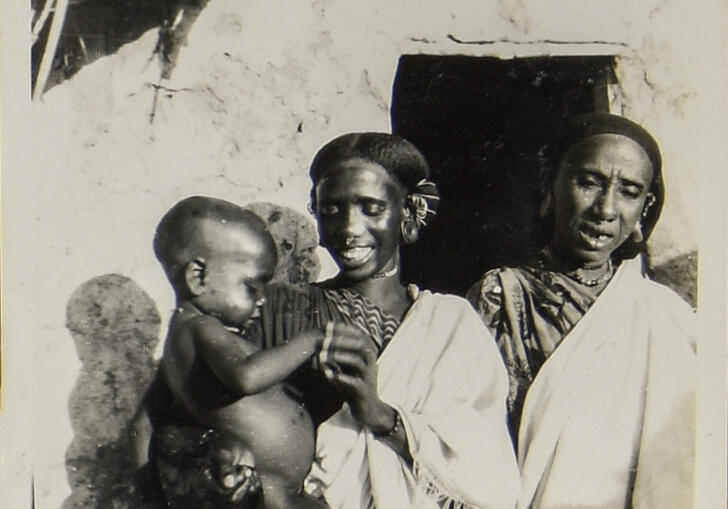 Two women and a child, smiling.