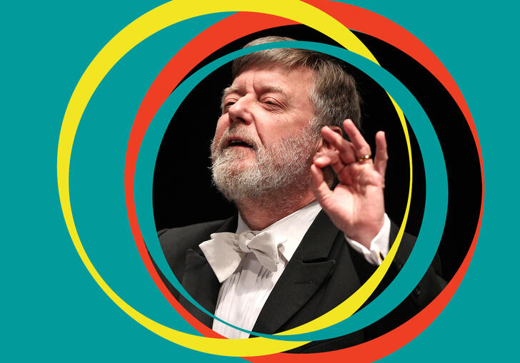 Sir Andrew Davis conducts, with green BBC SO branding around his centred image