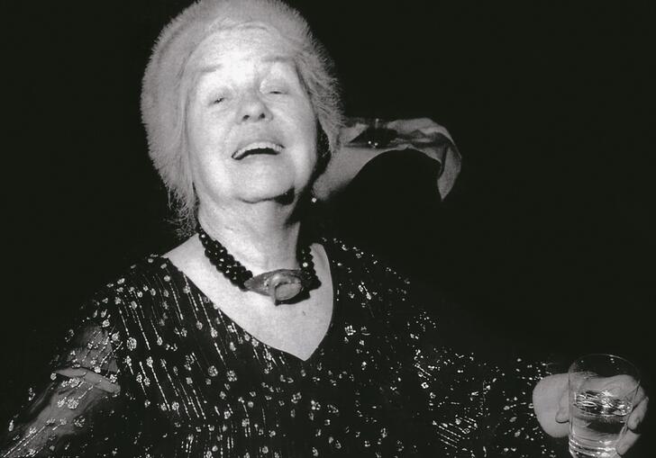 black and white photo of Alice Neel at a party