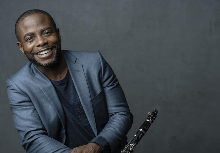 Anthony McGill smiling at the camera and holding his clarinet