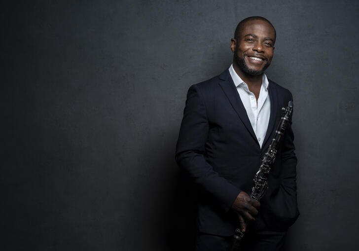 Anthony McGill smiling at the camera while holding his clarinet