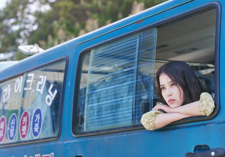 A woman leans out of a van in a still from Broker