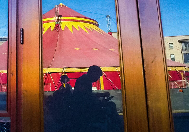 Reflected image in a window of a man in a wheelchair