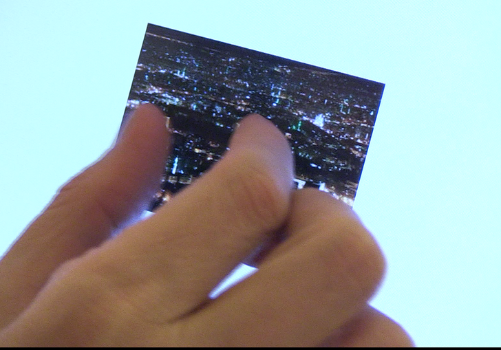 A hand grasps a microfilm 
