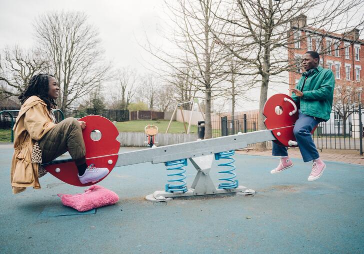 Two people enjoy a ride on a seesaw 