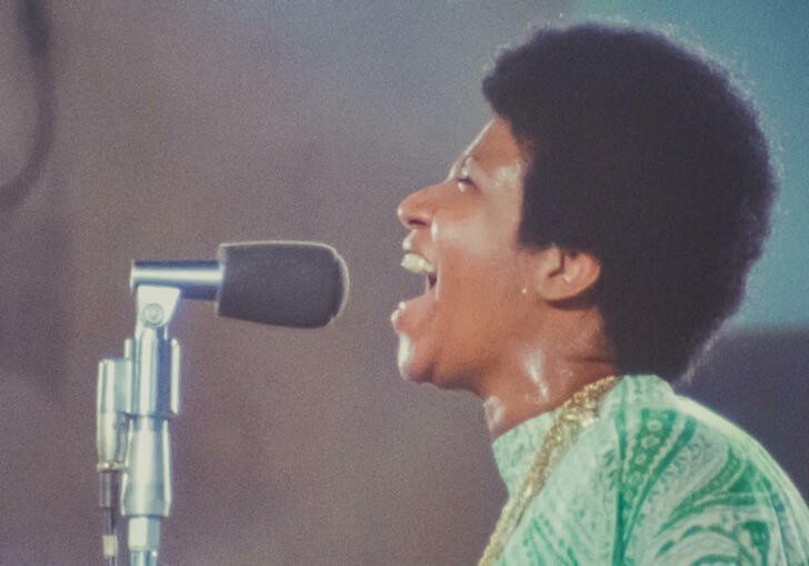 Aretha Franklin sings into a mic 