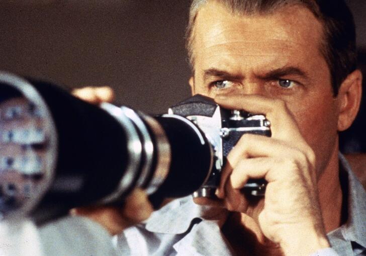 A man looks into a long telephoto lens