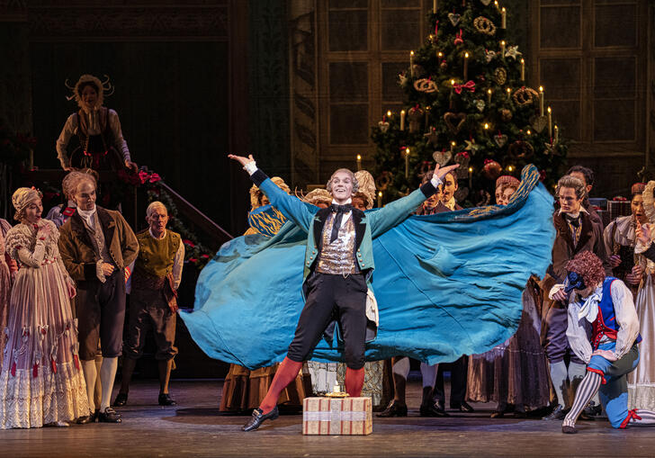 A man dances on a stage full of people in The Nutcracker
