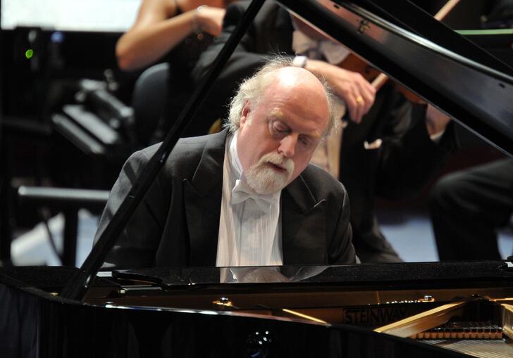 Peter Donohoe playing the piano on stage