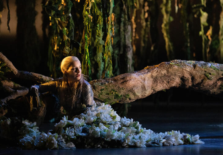 A spirit sits under a tree on stage