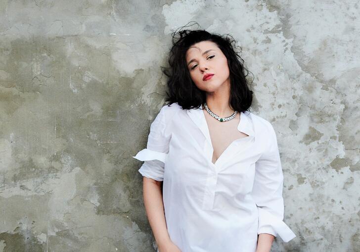 Khatia Buniatishvili standing against a stone wall