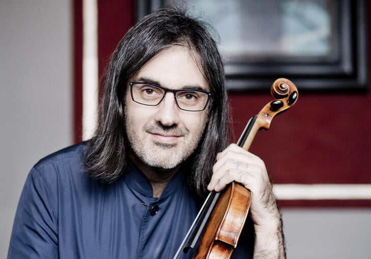 Leonidas Kavakos looking at the camera while holding his violin
