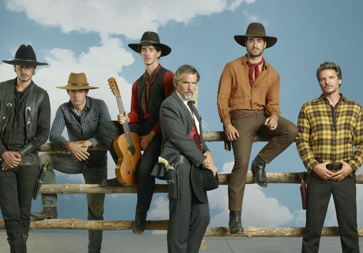 A group of 5 cowboys stand in front of a wooden fence against a blue background.