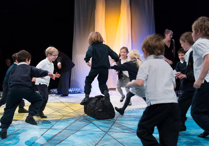 A group of children play in The Pit theatre during a performance of Get Happy