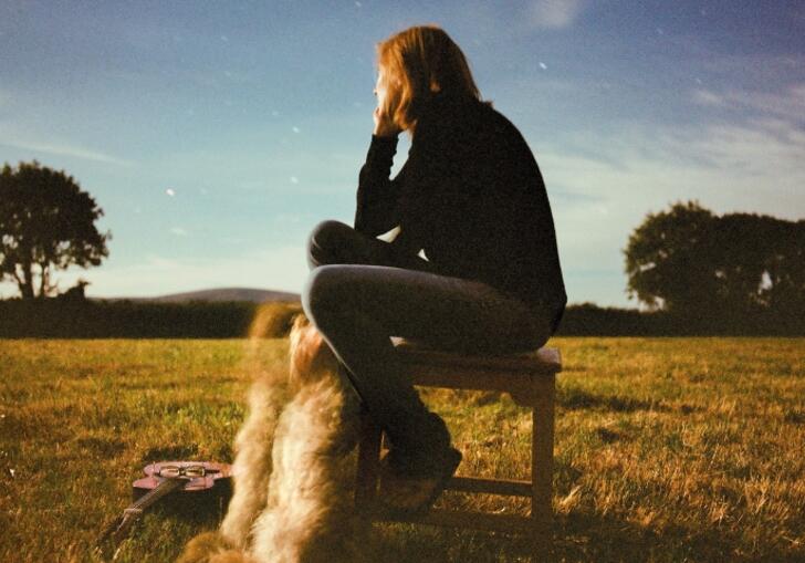 Beth Gibbons sitting on a chair under a starry sky