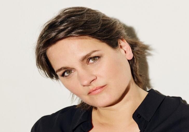 Madeline Peyroux, wearing black, looking into the camera 