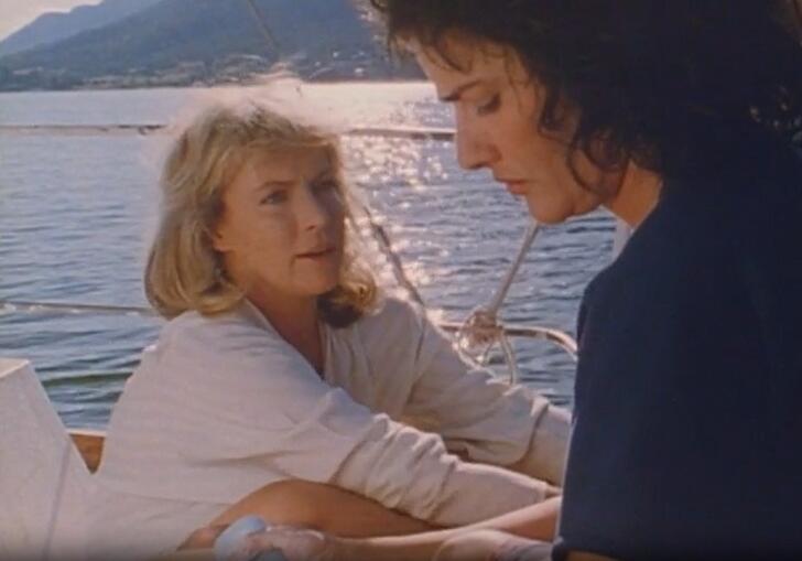 Two women chat on a boat on a glorious, sunny Mediterranean ocean. 