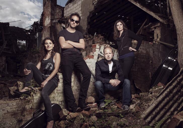 The Carducci Quartet sitting amongst the ruins of a brick building