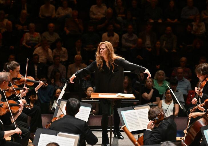 Barbara Hannigan conducting the LSO, arms outstretched to either side.