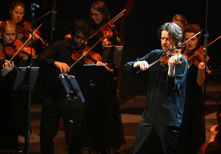 Britten Sinfonia on stage, playing violins