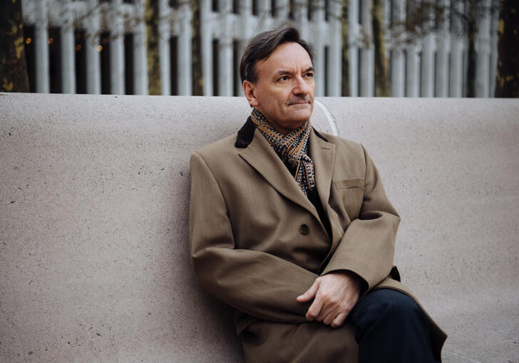 Stephen Hough sitting on a concrete bench