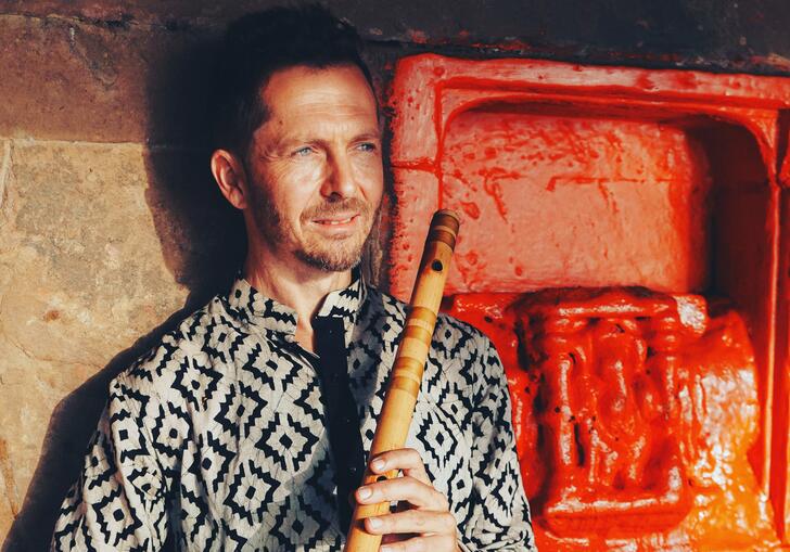 Jason Kalidas holding a bansuri