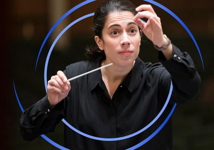 Marie Jacquot conducting, with blue circular swirls around her