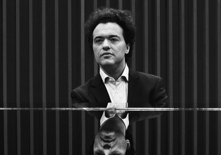 Black and white photo of Evgeny Kissin sitting at a piano
