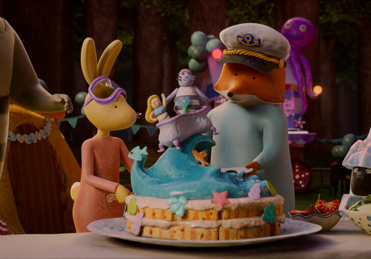 A group of animals stand in a house around a birthday cake. 