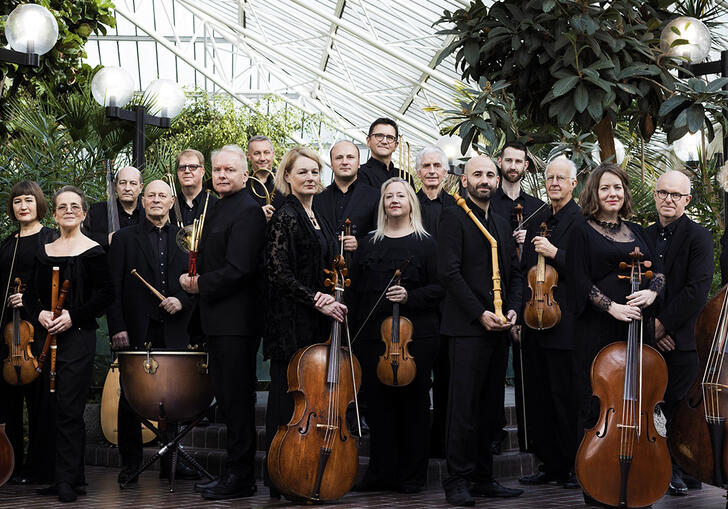 The Academy of Ancient music posing with their instruments in the Barbican Conservatory