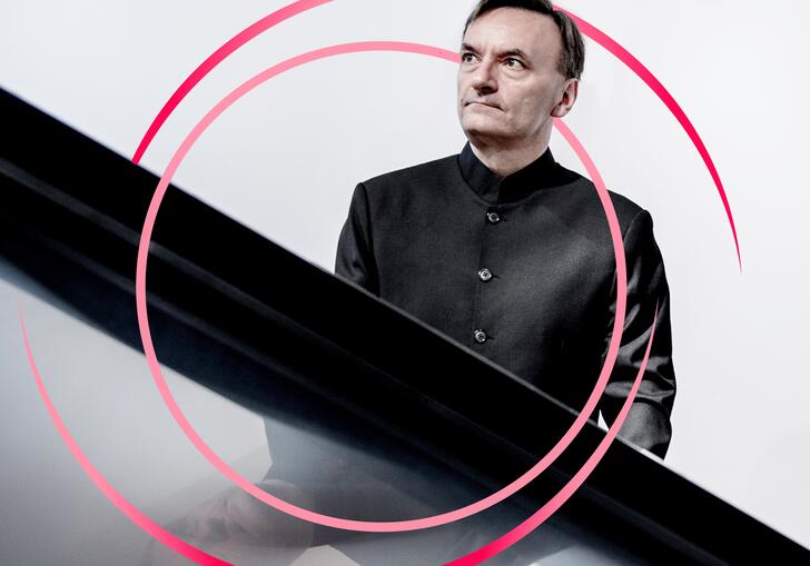A photo of Stephen Hough with pink circular swirls around him