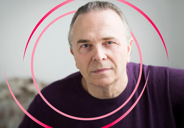 A photo of Mark Elder with pink circular swirls around him