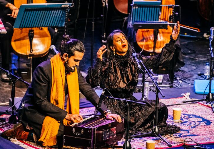 Rushil Ranjan and Abi Sampa sitting on stage performing