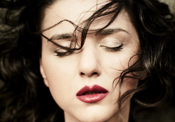 Close up shot of Khatia Buniatishvili with her eyes closed and her hair blowing in her face