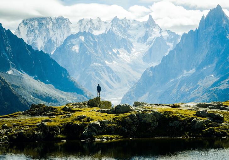 A man looking out at a vast mountainous landscape